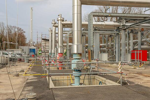 Die Geothermieanlage neben dem Heizkraftwerk: Durch die roten Rohre fließt das heiße Thermalwasser aus der Tiefe hoch, über die blauen wird es abgekühlt wieder in die Tiefe geleitet.