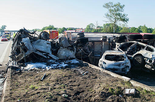 Rettungskräfte arbeiten am 13.06.2013 auf der Autobahn A8 bei Sulzemoos (Oberbayern) an einem ausgebrannten Lastwagen. Zwei weitere Autos sind in den Auflieger des Lastwagens gefahren. Bei dem Unfall kam mindestens eine Person ums Leben
