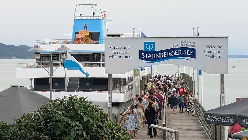 Menschen strömen am Starnberger See auf eines der Ausflugsschiffe. Menschen strömen am Starnberger See auf eines der Ausflugsschiffe.