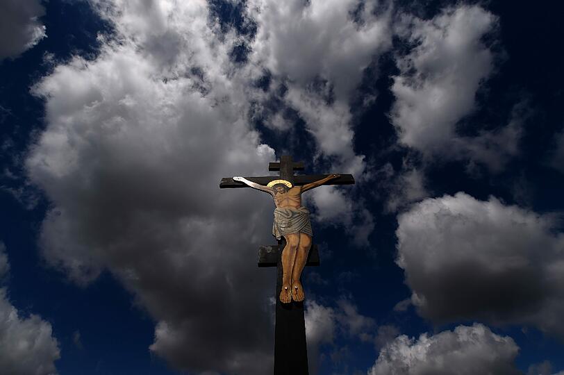 Ein Kreuz mit einer Jesus-Figur ragt in Griechenland in den Himmel.