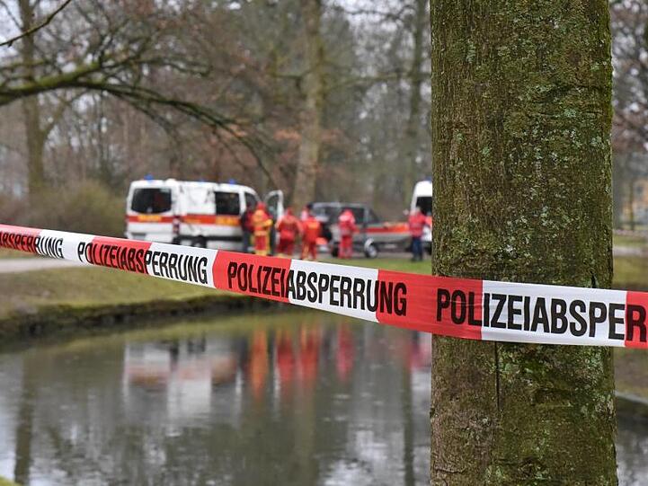 Rettungskräfte stehen an einem Kanal im Hofgarten. Foto: Rudi Ziegler/dpa