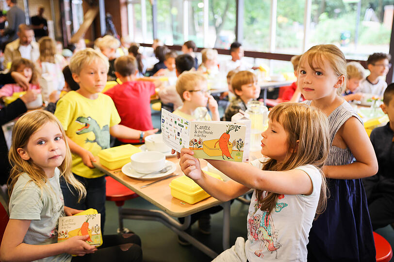 Schülerinnen und Schüler sitzen bei einem gemeinsamen Frühstück in der Grundschule. Geht es nach den bayerischen Grünen, sollen Schüler künftig ein kostenfreies Mittagessen erhalten. Schülerinnen und Schüler sitzen bei einem gemeinsamen Frühstück in der Grundschule. Geht es nach den bayerischen Grünen, sollen Schüler künftig ein kostenfreies Mittagessen erhalten.