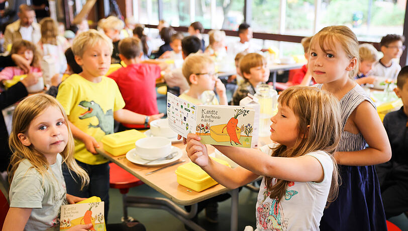 Sch&uuml;lerinnen und Sch&uuml;ler sitzen bei einem gemeinsamen Fr&uuml;hst&uuml;ck in der Grundschule. Geht es nach den bayerischen Gr&uuml;nen, sollen Sch&uuml;ler k&uuml;nftig ein kostenfreies Mittagessen erhalten.