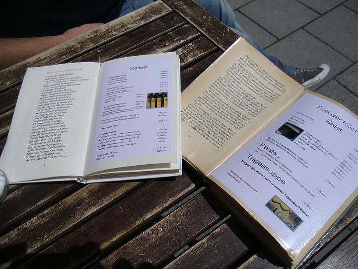 Der Wirt des Cuccuma Cafes hat seine Angebote in alte Bücher geklebt. Eine originelle Idee.