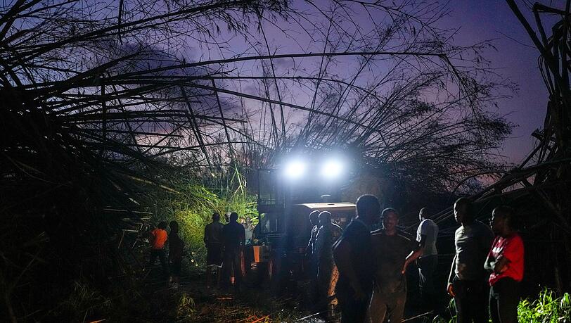 Arbeiter räumen umgestürzte Bäume und Trümmer beiseite. Arbeiter räumen umgestürzte Bäume und Trümmer beiseite.