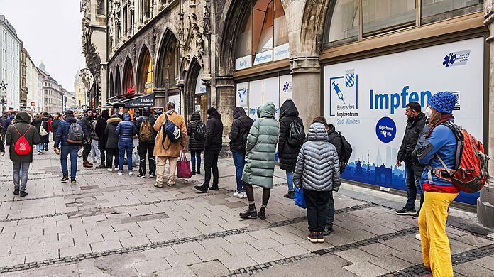 Menschen stehen vor dem ehemaligen Sport Münzinger am Rathaus Schlange. Hier wird mittlerweile auch geimpft.