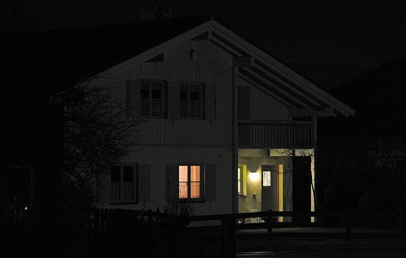 Lichtschein ist in einem Haus zu sehen. Zuvor hatten Einsatzkräfte der Polizei eine 55-jährige Frau tot in ihrer Wohnung gefunden.
