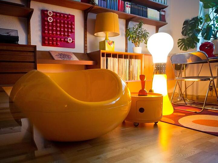Die Stehlampe "Birillo" von Carlo Nason, ein Möbelcontainer von Anna Castelli mit dem Namen "Componibili" und der Fiberglas-Sessel "Pastille" von Eero Aarnio.