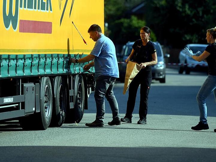 Polizisten untersuchen an einem Tatort einen LKW, in dessen Plane ein Pfeil steckt. Foto: Marcus Merk