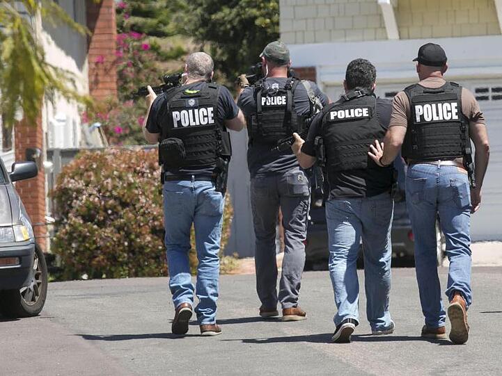Schwer bewaffnete Polizisten aus San Diego nähern sich einem Haus, in dem der Täter eines Anschlags auf die Chabad of Poway Synagoge vermutet wird.