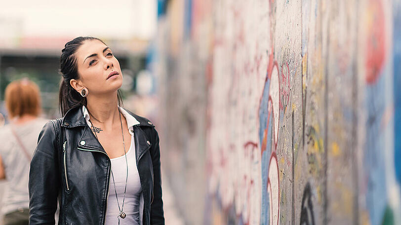 Mit den folgenden Apps müssen Sie die Reste der Berliner Mauer nicht so fragend ansehen, wie diese junge Frau