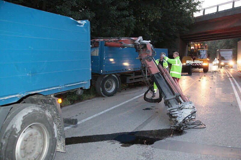 Bei Mühldorf ist ein Lkw mit Ladekran gegen eine Brücke gekracht. Der Kran wurde dabei aus der Verankerung gerissen und landete auf der Straße. Die Bilder.