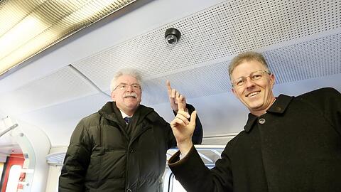 Bitte lächeln: Bayerns Verkehrsminister Martin Zeil (l.) und der Münchner S-Bahn-Chef Bernhard Weisser deuten auf eine der neuen Kameras in einem S-Bahn-Zug.