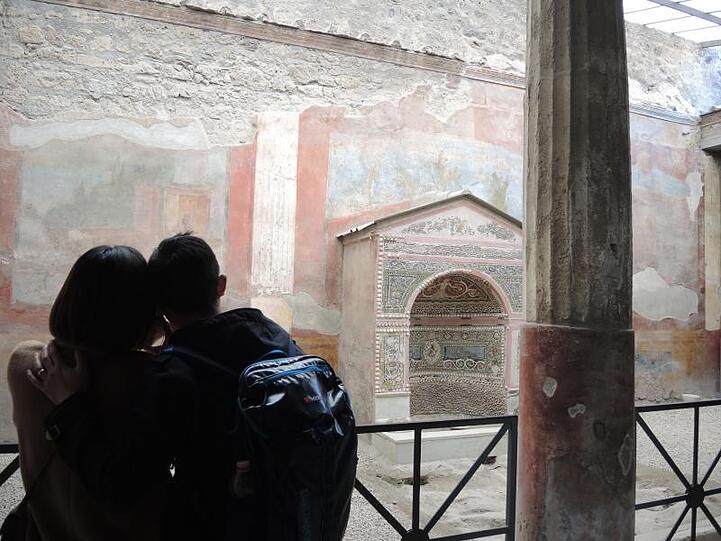 Ein junges Paar betrachtet einen Brunnen im Archäologischen Park Pompeji.