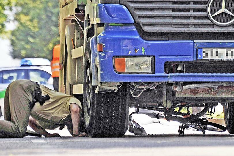 Nach dem tödlichen Unfall in Neuperlach: Ein Polizist bückt sich unter den Lkw &ndash; darunter liegt noch das Radl des Opfers (57).