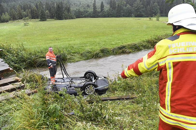 Bei Bayerischzell am Schliersee landet ein Passat kopfüber in einem stark überfluteten Bach. Der Fahrer kann in letzter Sekunde gerettet werden. Die Bilder des Unfalls.