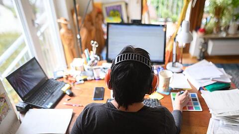 Eine Frau arbeitet mit Hörschutz im Homeoffice.