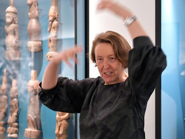 Wiebke Arndt, Leiterin des Bremer Überseemuseums, gestikuliert vor einer Vitrine mit Exponaten.