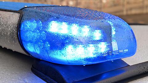 Ein Streifenwagen der Polizei steht mit eingeschaltetem Blaulicht an einem Einsatzort.