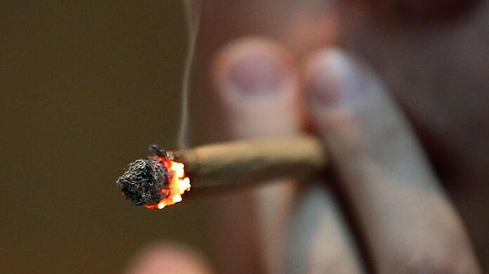 Ein Mann raucht einen Joint mit Marihuana. (Symbolbild)