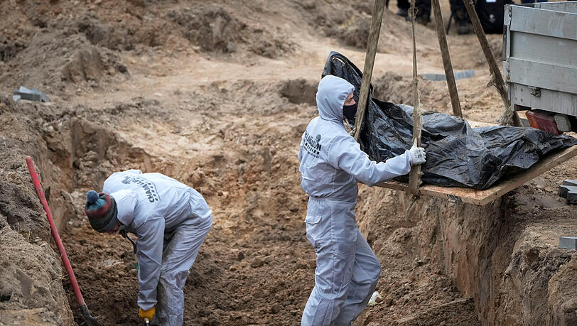 Butscha: Männer in Schutzkleidung exhumieren Leichen von Zivilisten, die während der russischen Besatzung getötet wurden. (Archivbild, April 2022)