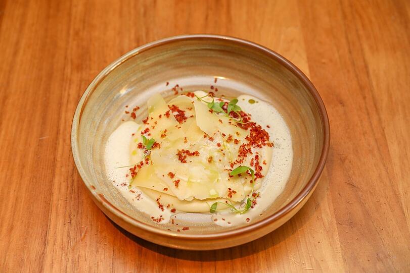 Dritter Gang: Hausgemachter Raviolo mit Rahmwirsing-Speck-Füllung, gehobeltem Parmesan und Selleriepüree
