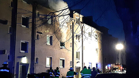 Rauch steigt aus einem Fenster der brennenden Wohnung auf.