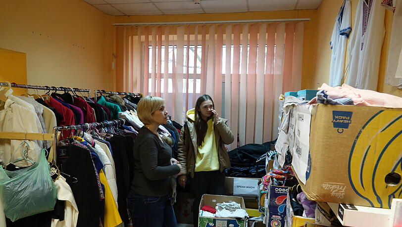Natalija Timofejewa (l.), ehrenamtliche Mitarbeiterin der ukrainischen Hilfsorganisation "Freiwilligenarmee" (Armija Wolonteriw) in Kiew. Sie wählt mit der Besucherin Julia Abusowa Babykleidung aus.