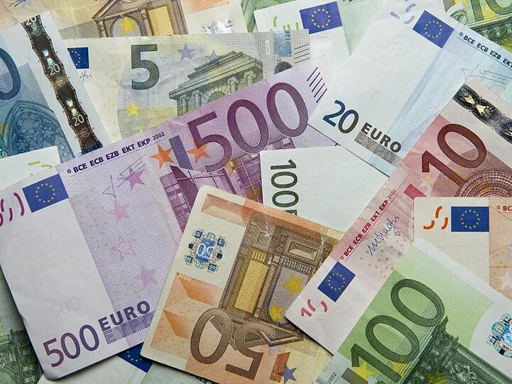 Zahlreiche Euro-Banknoten liegen auf einem Haufen. Foto: Daniel Reinhardt/dpa/Archivbild