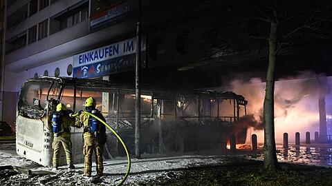 Feuerwehrmänner löschen an der Berliner Sonnenallee einen Reisebus, der in der Silvesternacht von Unbekannten angezündet wurde.