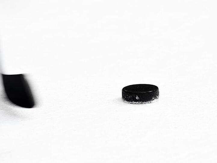 Ein Puck und ein Eishockeyschläger. Foto: Tobias Hase/archiv