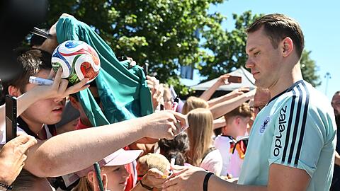 Manuel Neuer schreibt Autogramme f&uuml;r die DFB-Fans.