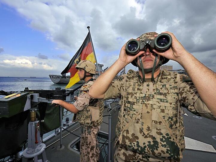 Deutsche Marine-Soldaten halten an Bord der Fregatte "Karlsruhe" an einem Maschinengewehr Wache.