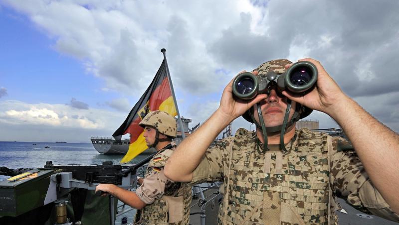 Deutsche Marine-Soldaten halten an Bord der Fregatte "Karlsruhe" an einem Maschinengewehr Wache. Deutsche Marine-Soldaten halten an Bord der Fregatte "Karlsruhe" an einem Maschinengewehr Wache.