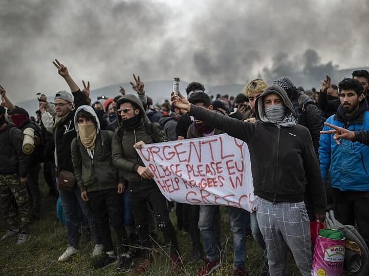 Protestierende Migranten halten ein Banner mit der Aufschrift "Schnell, Bitte, Bitte EU, helft den Migranten in Griechenland" bei Zusammenstößen mit der Polizei in der Nähe von Thessaloniki.