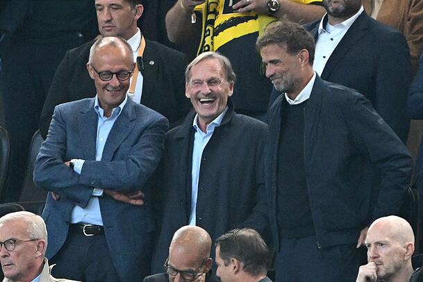 Hochkar&auml;tig besetzte Trib&uuml;ne: Bundeskanzler Friedrich Merz (l), Ligapr&auml;sident Hans-Joachim Watzke (M) und Bundestrainer J&uuml;rgen Klopp.
