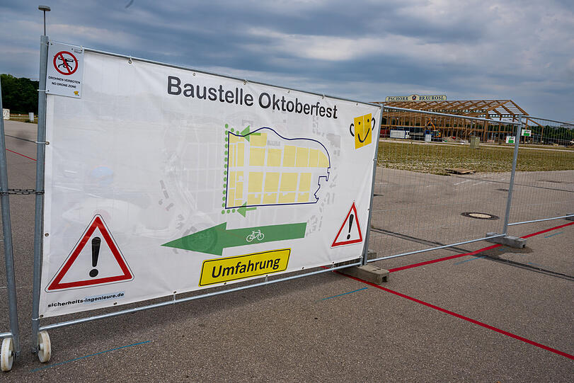 Ein Plakat mit der Aufschrift "Baustelle Oktoberfest - Umfahrung" hängt zu Beginn des offiziellen Start zum Oktoberfest-Aufbau an einem Tor des ansonsten eingezäunten Wiesn-Gelände.