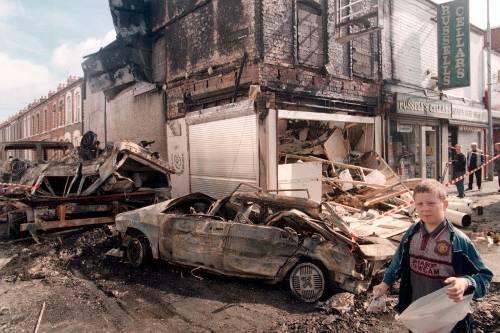 Tage des Donners: Ein Bub läuft am 10. Juli 1996 an zerbombten Autos und Häusern in Belfast vorbei.