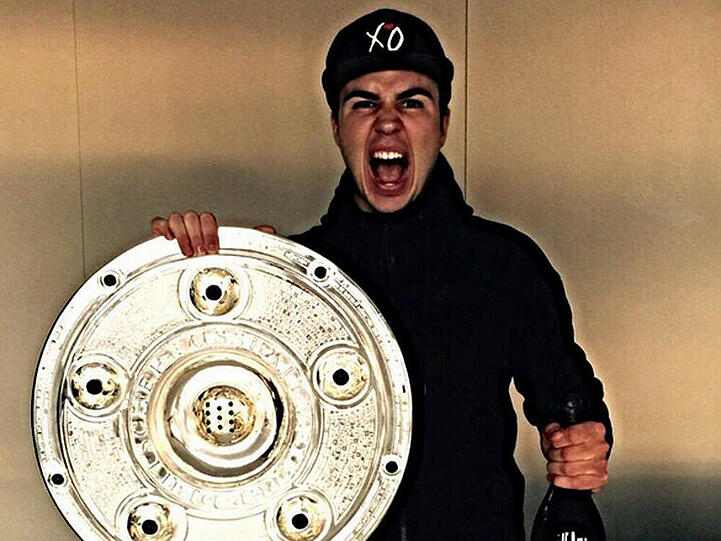 Mario Götze feiert mit Meisterschale und Champagner