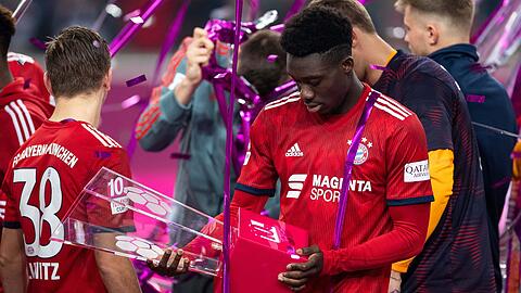 Telekom-Cup: Alphonso Davies aus Kanada betrachtet nach dem gewonnen Finale den Pokal.