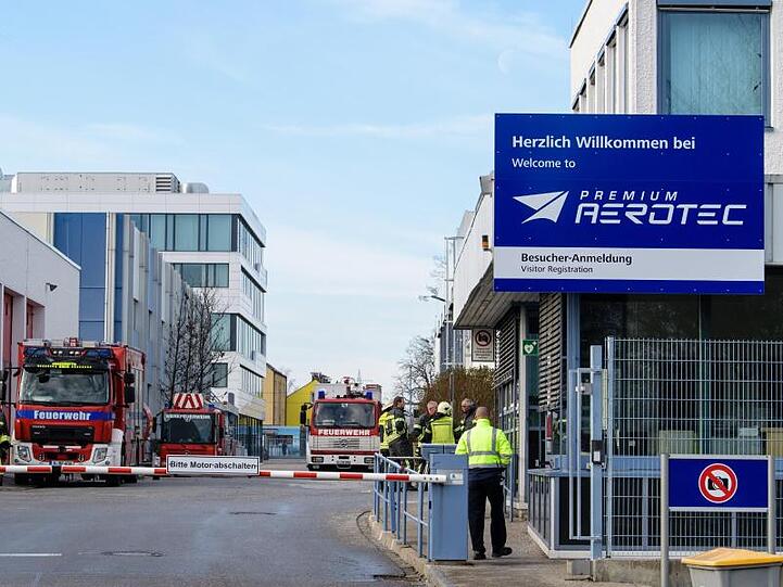 Feuerwehrmänner stehen auf dem Firmengelände vom Luftfahrtzulieferer Premium Aerotec. Foto: Matthias Balk/Archivbild