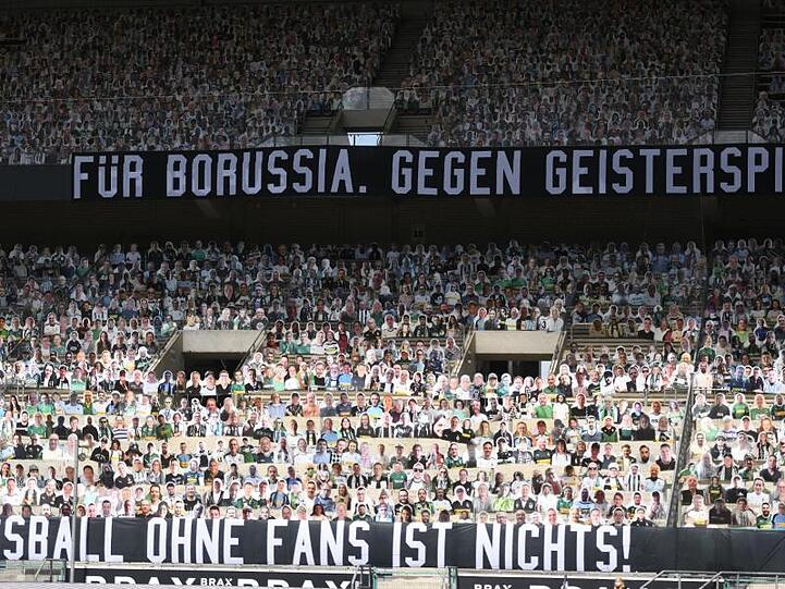 Fotos von Fans sind auf Pappfiguren auf der Tribüne des Borussia-Parks aufgestellt.