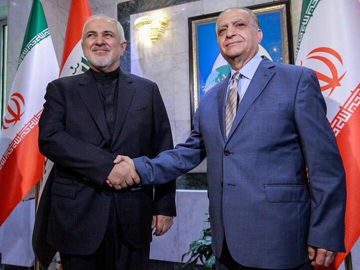 Iraks Außenminister Mohammed Ali Al-Hakim (r) begrüßt seinen iranischen Amtskollegen Mohammed Dschawad Sarif in Bagdad.
