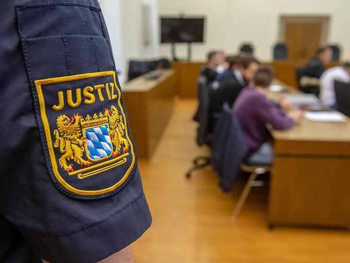 "Justiz" steht am Ärmel eines Justizvollzugsbeamten im Verhandlungssaal des Landgerichts. Foto: Armin Weigel/Archiv