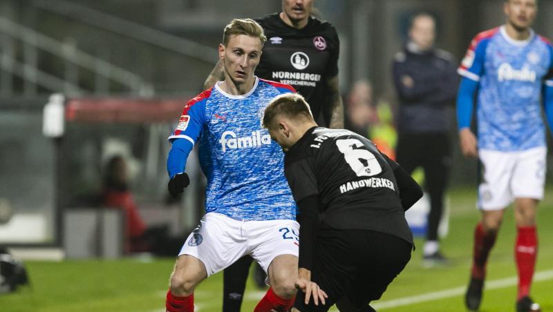 Kiels Joshua Mees (l.) spielt Nürnbergs Tim Handwerker den Ball durch die Beine.