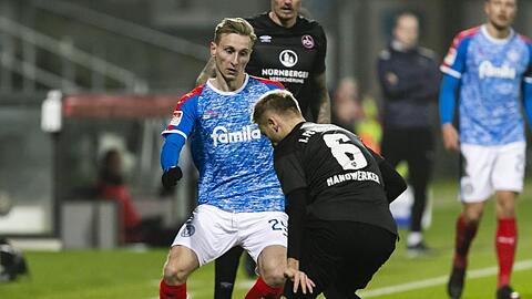 Kiels Joshua Mees (l.) spielt Nürnbergs Tim Handwerker den Ball durch die Beine.