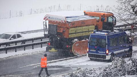 Ein Fahrzeug vom Winterdienst fährt durch eine Engstelle, an der Bäume am Straßenrand umgefallen sind. Foto: Bernd März