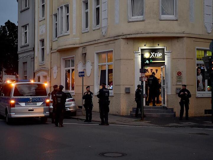 Polizisten stehen während einer Razzia vor einem Wettbüro.