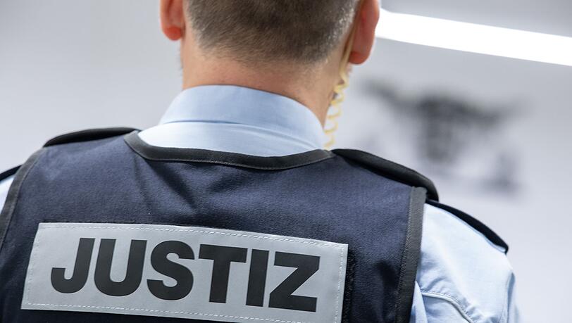 Ein Justizbeamter steht in einem Gerichtssaal.
