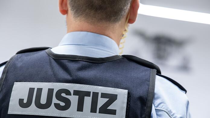 Ein Justizbeamter steht in einem Gerichtssaal.